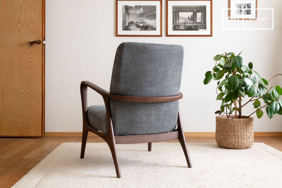 This armchair features a sleek, curved design with a dark stained solid ash frame