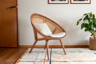 Walnut-coloured armchair in solid ash and wicker